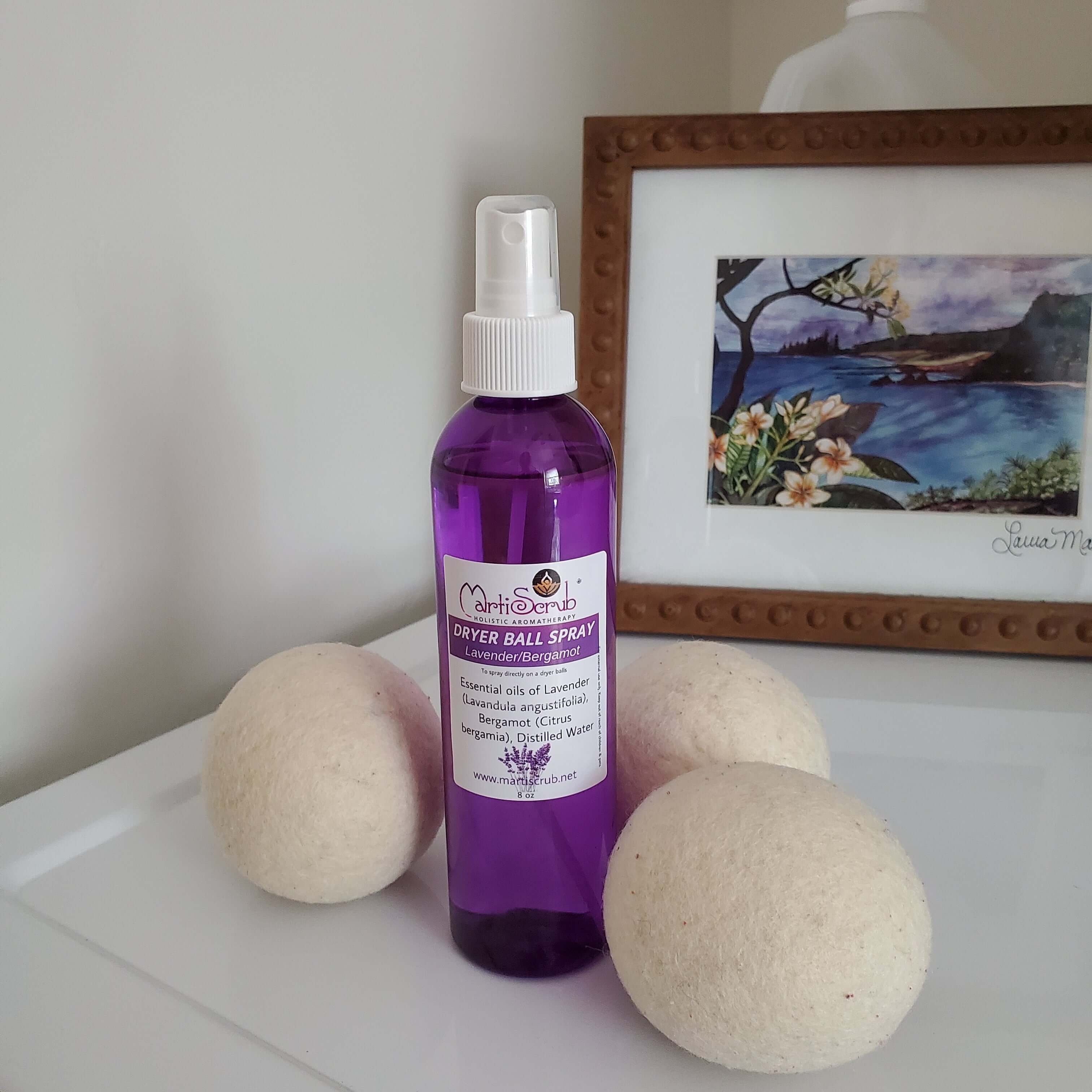 Wool dryer balls and lavender-scented dryer ball spray on a table, perfect for natural laundry freshening.