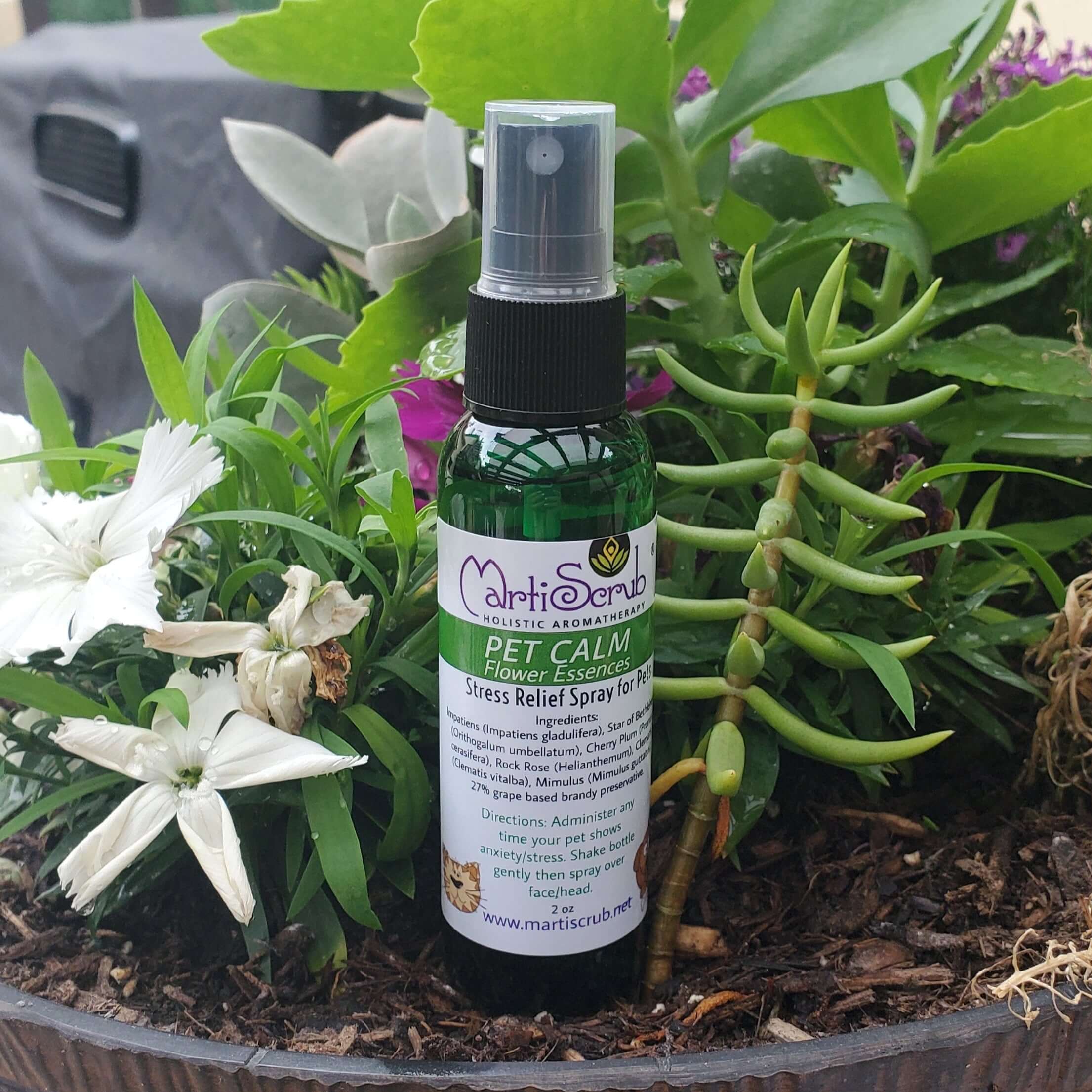 Pet Calm stress relief spray for pets, made with flower essences, surrounded by vibrant flowers and greenery.