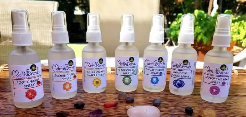 Seven chakra spray bottles with essential oil blends and crystals for energy alignment and balance.