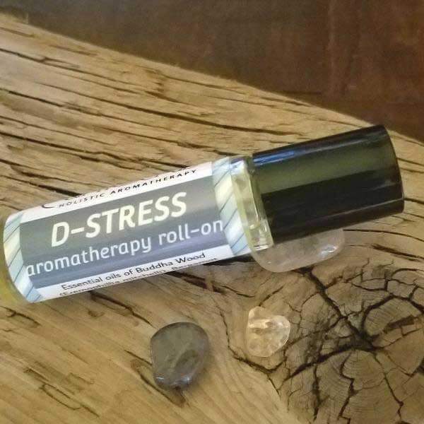 D-Stress grounding essential oil roll-on with Buddha Wood on a wooden surface, promoting relaxation and meditation.