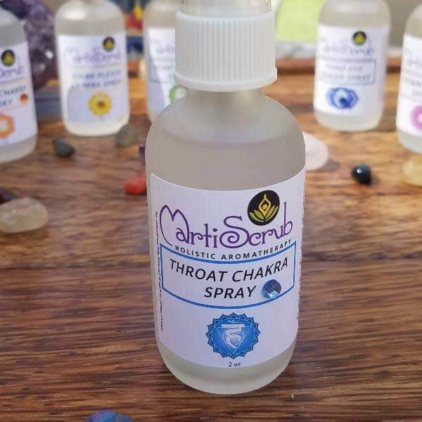 Throat Chakra Spray bottle by MartiSerub on a wooden surface, featuring essential oil blend for sound and communication.
