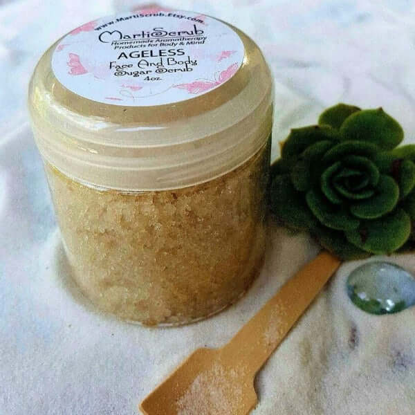 Ageless face and body sugar scrub in a 4oz jar with a wooden spatula, ideal for promoting youthful skin.