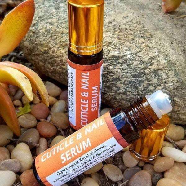 Aromatherapy cuticle and nail serum bottles with organic ingredients placed on natural stones.