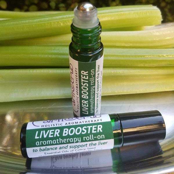 Liver Booster essential oil roll-on on a silver tray with celery background, promoting liver health and detoxification.